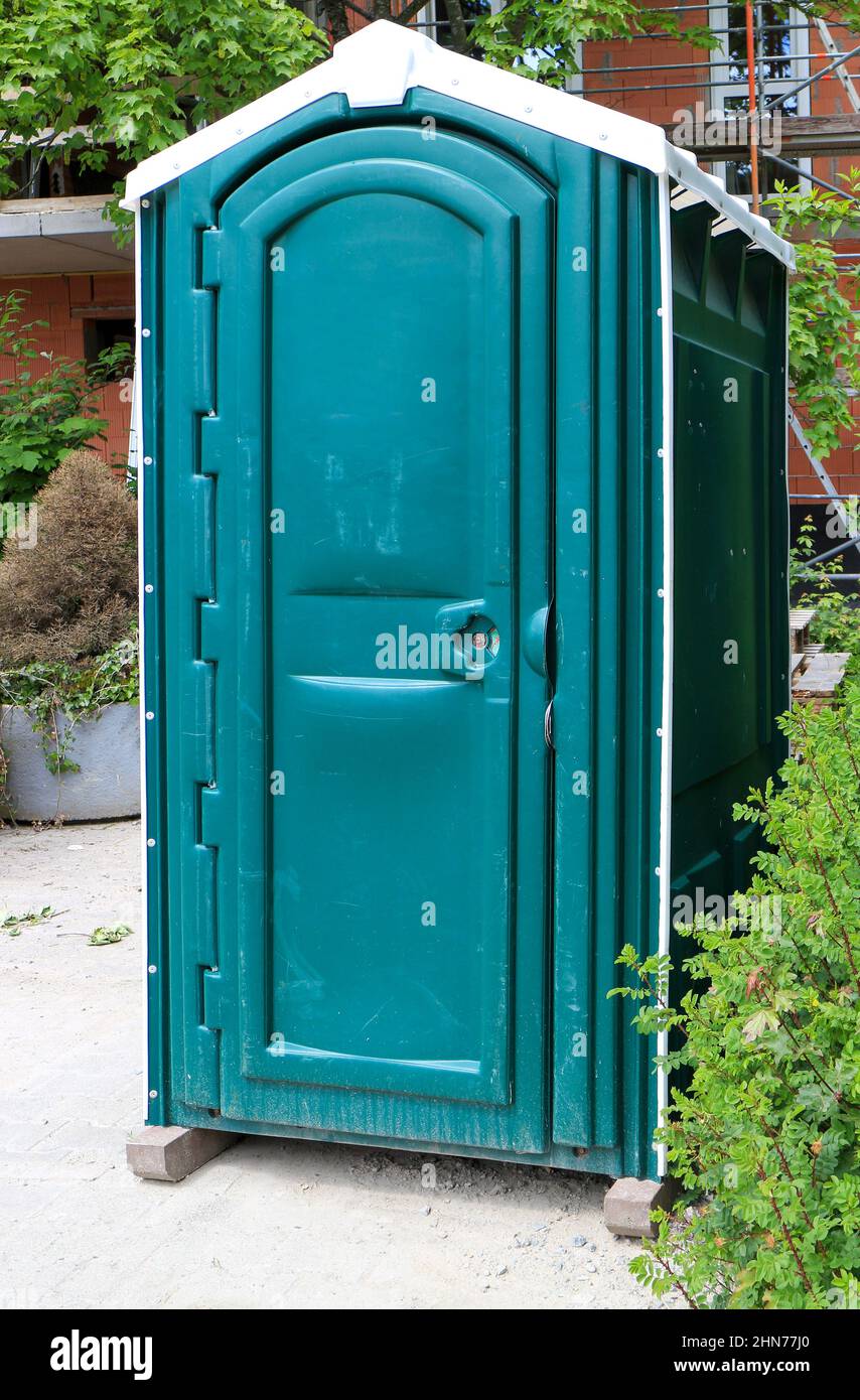 Grüne tragbare Toilette oder tragbare Toilette auf einer Baustelle Stockfoto