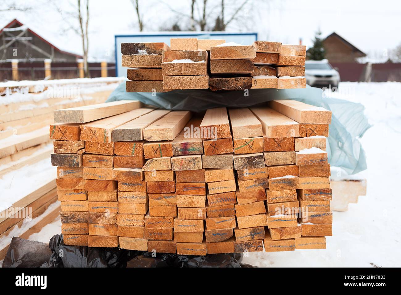 Holzbretter auf einem Stapel als Hintergrundstruktur gestapelt. Winterbau eines Holzhauses Stockfoto