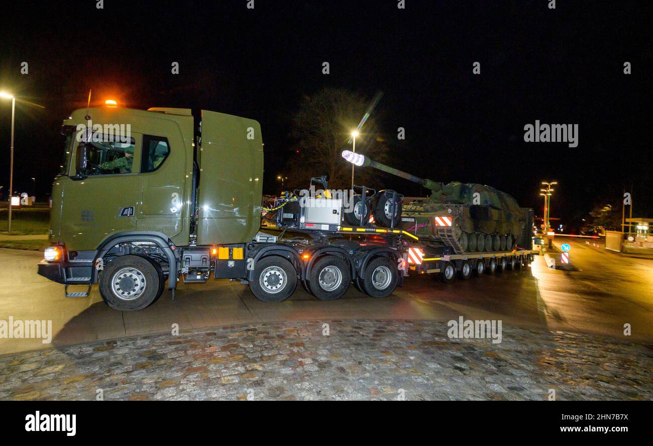 Münster, Deutschland. 14th. Februar 2022. Ein Tieflader der Bundeswehr verlässt die Hindenburger Kaserne mit einer selbstfahrenden Haubitze 2000 (PZH 2000) nach Litauen. Deutschland schickt ab Februar 14 rund 350 Soldaten und Frauen mit rund 100 Fahrzeugen, die mit verschiedenen Waffensystemen ausgestattet sind, in die baltischen Staaten. Quelle: Philipp Schulze/dpa/Alamy Live News Stockfoto