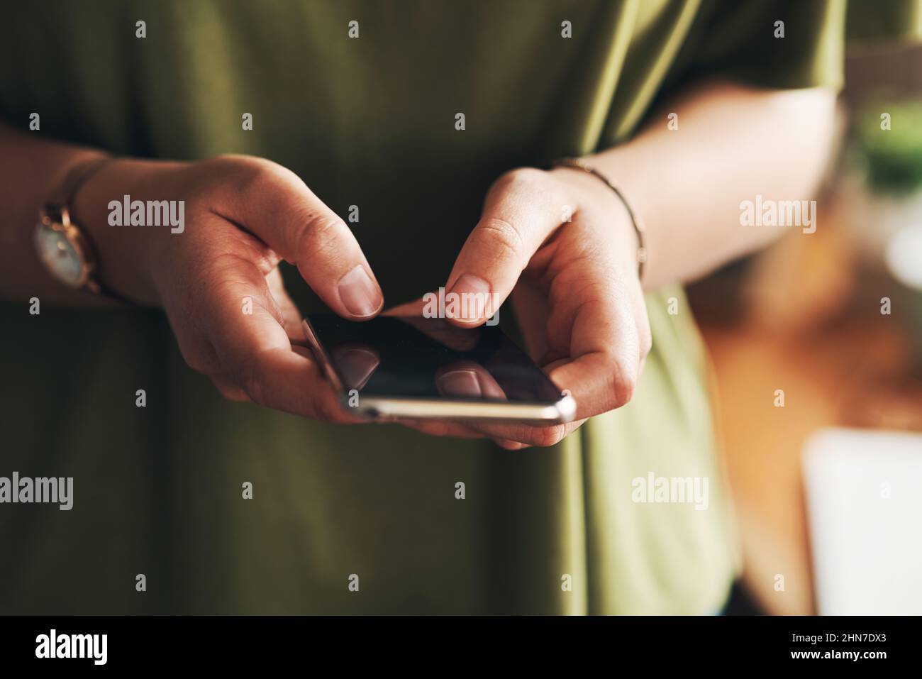 Die besten Benachrichtigungen kommen von neuen Kunden. Aufnahme einer nicht erkennbaren Frau, die ein Smartphone benutzt, während sie von zu Hause aus arbeitet. Stockfoto