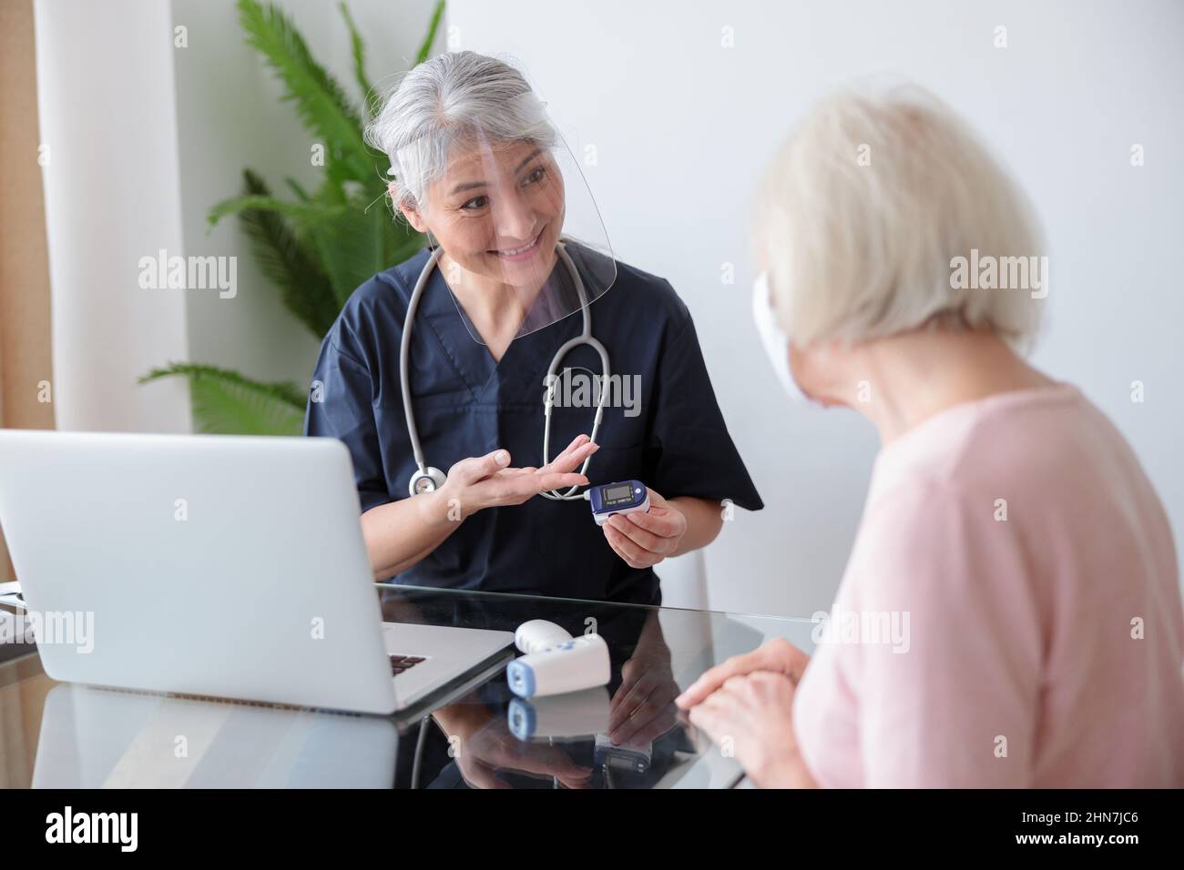 Alte Patientin mit ihrer Krankenschwester auf Termin Stockfoto