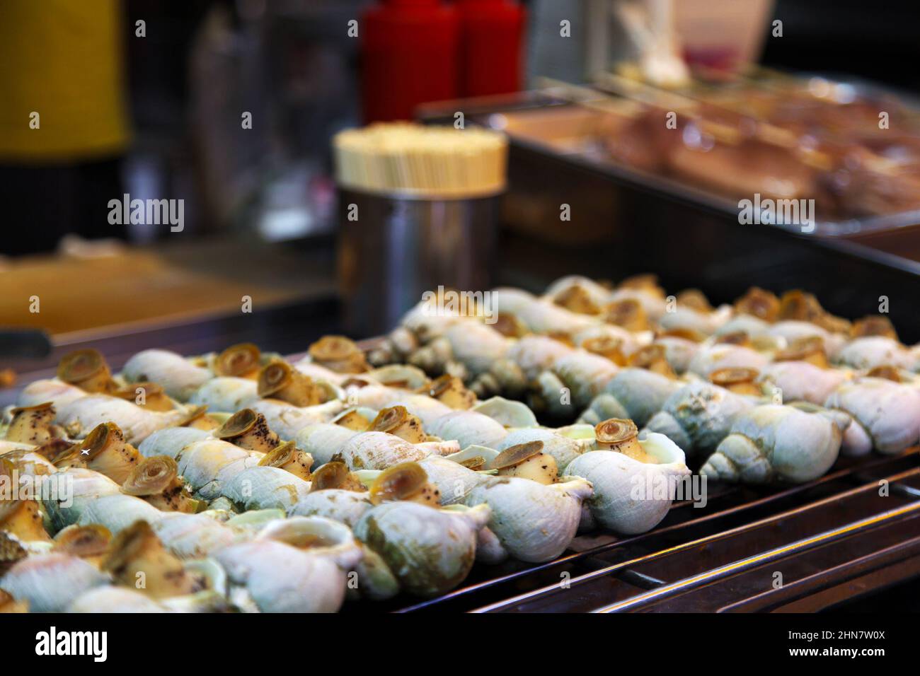 Street Food Gegrillte Schnecken werden als Snacks im Outdoor Jiu Fen Marktladen in Taiwan serviert. Sie werden mit Salz, schwarzem Pfeffer und scharfer Sauce serviert. Stockfoto