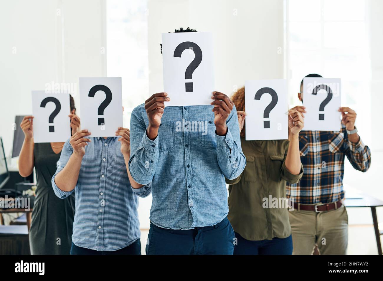 Wer Wie Was Wo Wann Warum. Aufnahme einer Gruppe von Geschäftsleuten, die Fragezeichen vor ihren Gesichtern halten. Stockfoto
