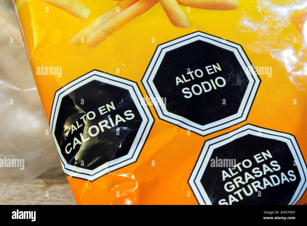 Lebensmitteletiketten auf einem Produkt. Übersetzung: 'Kalorienreich, natriumreich, reich an gesättigten Fetten' Stockfoto