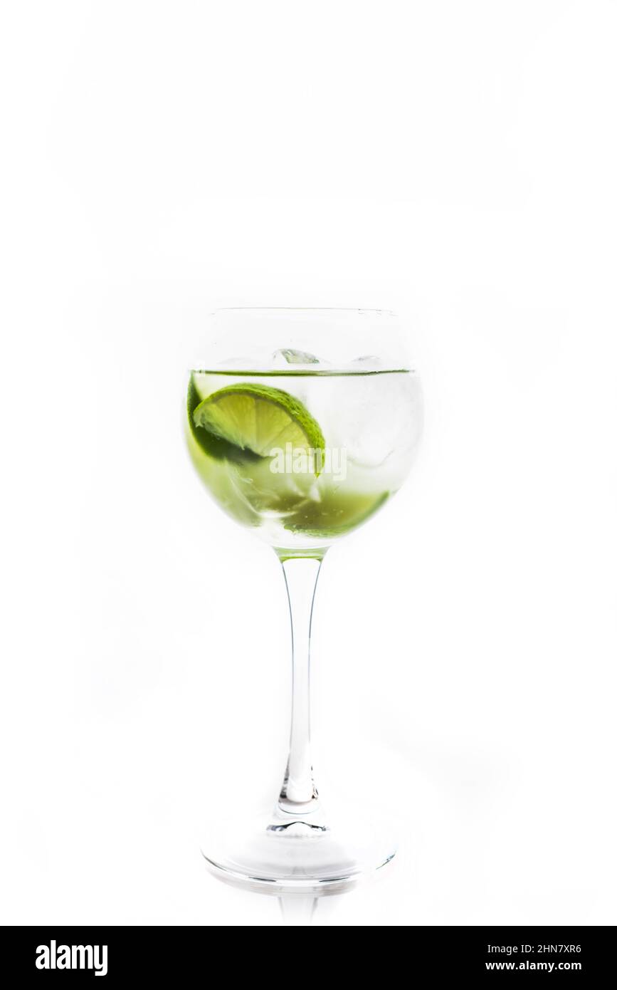 Cocktail auf Rum-Basis mit Limette im Weinglas (Variante cuba libre) auf rustikalem Hintergrund. Selektiver Fokus. Geringe Schärfentiefe. Stockfoto