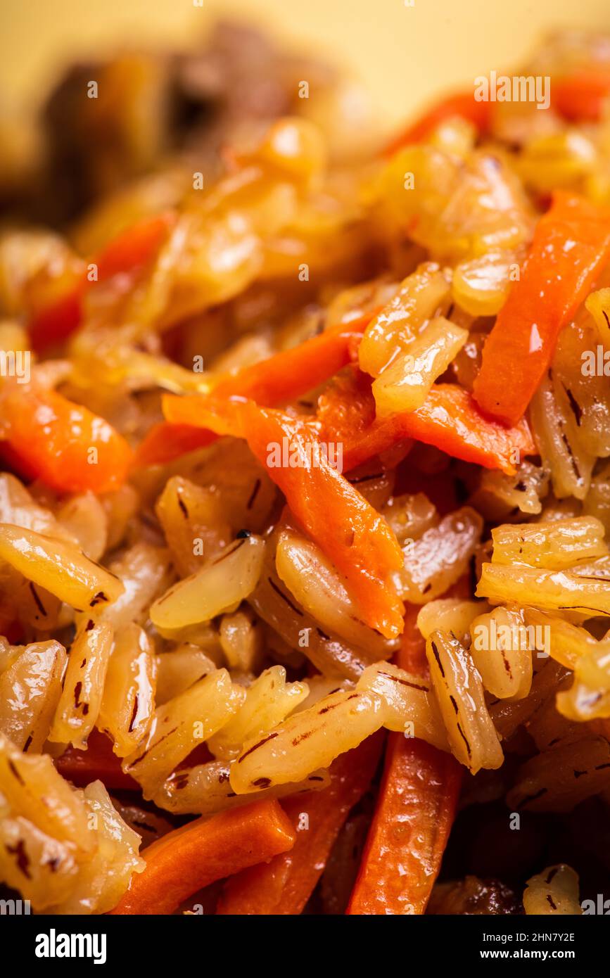 Traditionelle usbekische Pilaf auf dem rustikalen Hintergrund. Selektiver Fokus. Geringe Schärfentiefe. Stockfoto