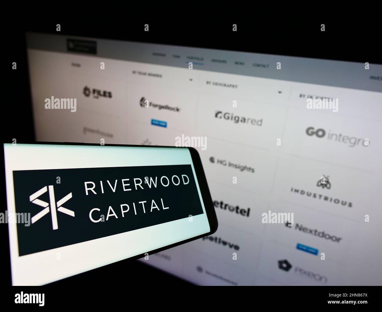 Smartphone mit Logo des amerikanischen Unternehmens Riverwood Capital Management L.P. auf dem Bildschirm vor der Website. Konzentrieren Sie sich auf die Mitte des Telefondisplays. Stockfoto