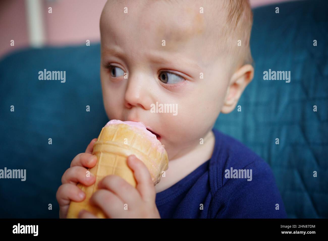 Kind isst rosa Eis Stockfoto