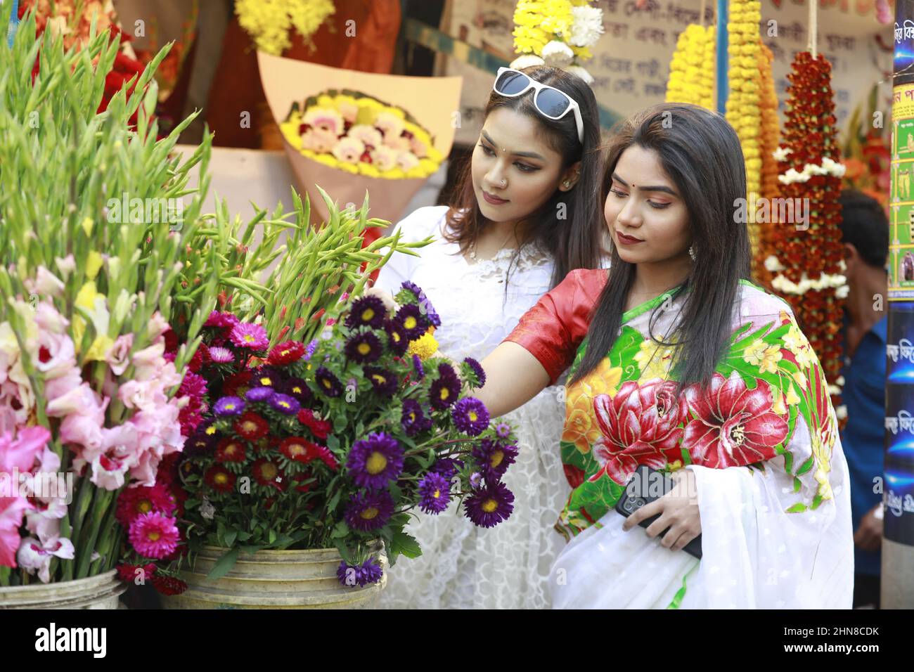 Frauen, die traditionelle Saris und Blumenkronen tragen, werden während des Frühlingsfestes in Dhaka, Bangladesch, am 14. Februar 2022 gesehen. In Bangladesch ist Pahela Falgun mit bunten Feierlichkeiten gekennzeichnet und traditionell tragen Frauen gelbe Saris und Männer Panjabi, um diesen Tag zu feiern. Die Feier von Pahela Falgun ist als Bosonto Utsob bekannt. Foto von Suvra Kanti das/ABACAPRESS.COM Stockfoto