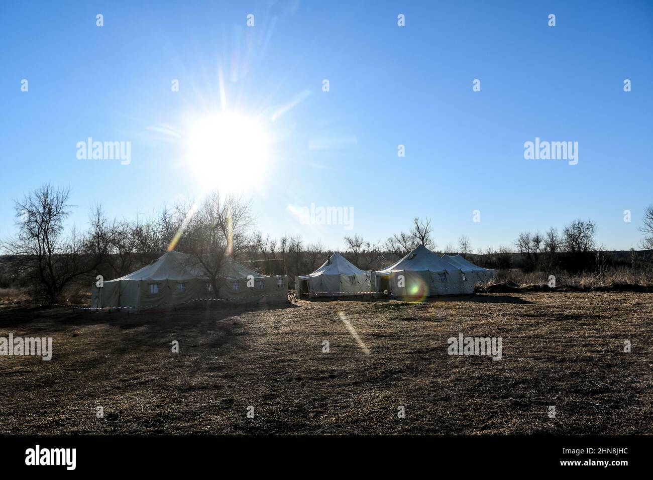 REGION ZAPORIZHZHIA, UKRAINE - 14. FEBRUAR 2022 - die Sonne scheint über den Zelten des innerhalb von 24 Stunden in Zaporizhzh erlegten Militärausbildungszentrums Stockfoto