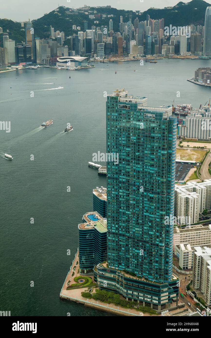 Luftaufnahme aus dem Hubschrauber des Harbourfront Landmark, einer luxuriösen Wohnanlage mit 3 Türmen in Hung Hom, Kowloon, mit der Insel Hong Kong über Victoria Harbo Stockfoto