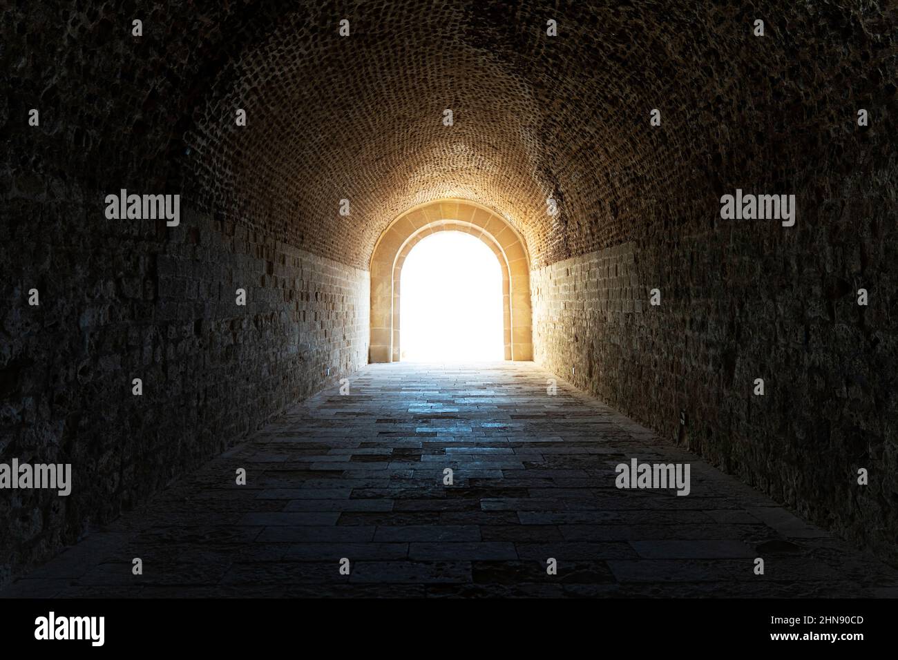 Der dunkle Tunnel in der Katakombe. Licht am Ende des Tunnels Stockfoto