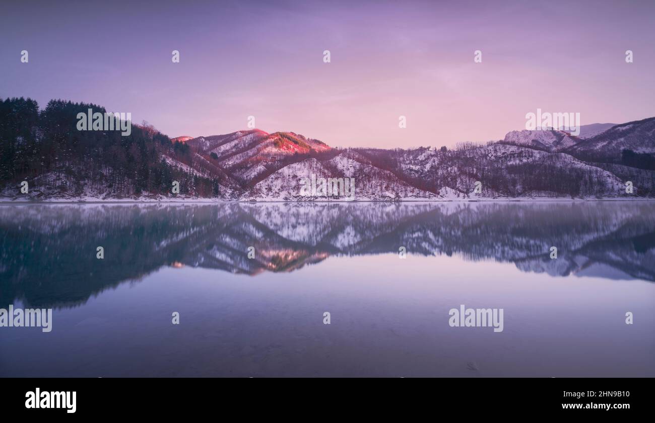 Gramolazzo See und Schnee in den Apuanischen Bergen im Winter nach Sonnenuntergang. Garfagnana, Toskana, Italien, Europa. Langzeitbelichtung. Stockfoto