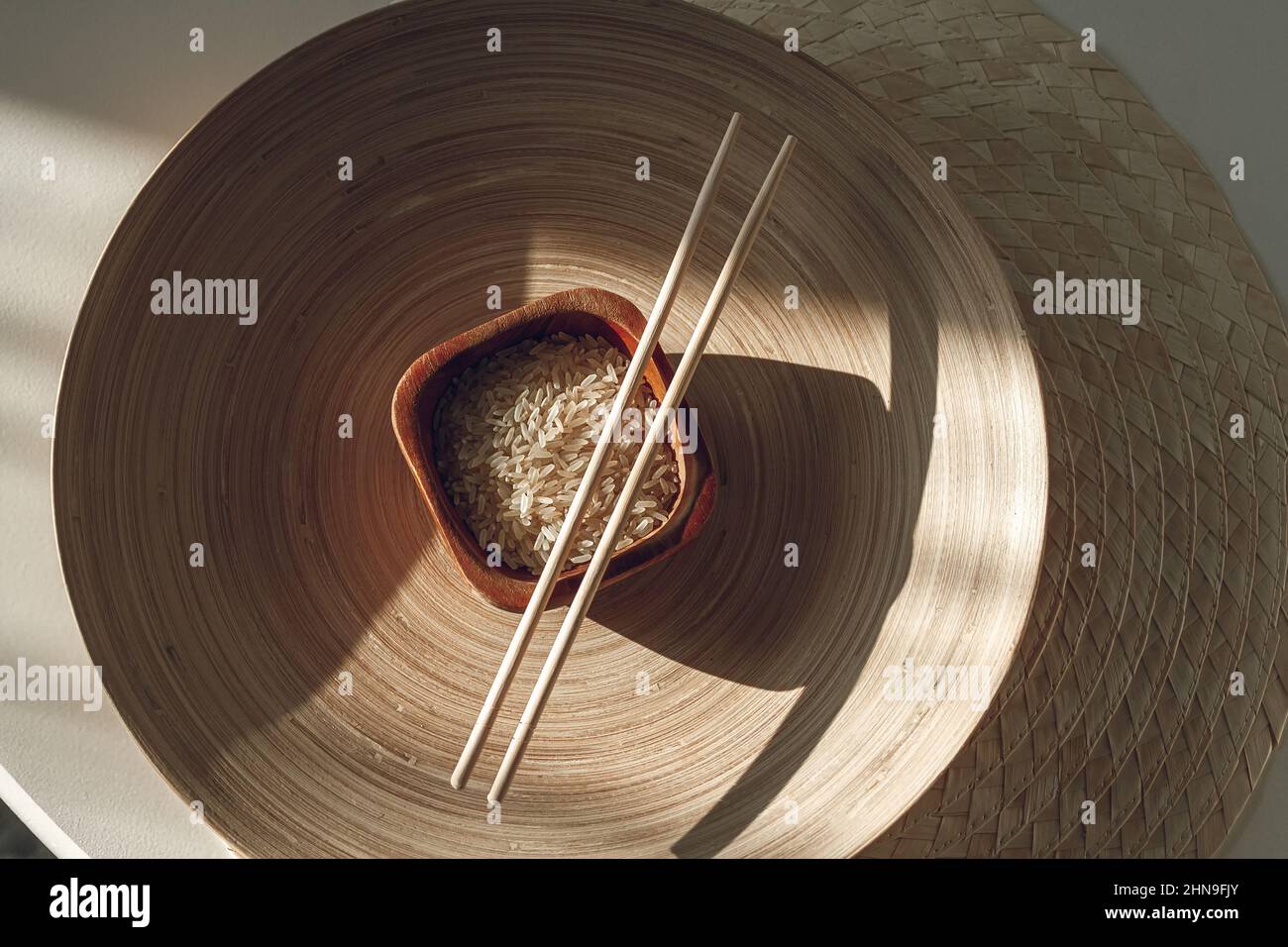 Parboiled Reis in Holzschüssel mit Holzstäbchen Stockfoto