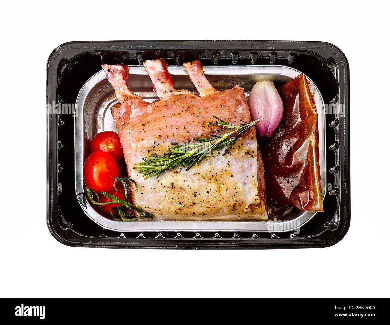 Mini-Räucherwürste in Kunststoffschale isoliert auf weiß. Stockfoto