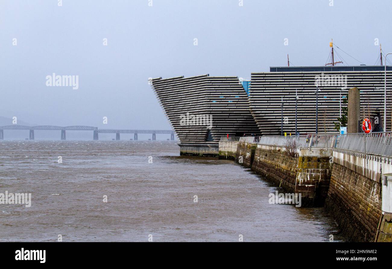 Dundee, Tayside, Schottland, Großbritannien. 15th. Februar 2022. Wetter in Großbritannien: Starke Westwinde haben schwere Regenwolken nach Nordostschottland gebracht, die sich später am Tag mit Temperaturen von 6 Grad verflüchtigen werden Winterlandschaften entlang der Uferpromenade von Dundee, von der Tay Road Bridge aus gesehen, mit spektakulärem Blick auf den Tay River, Riverside und das V&A Design Museum. Kredit: Dundee Photographics/Alamy Live Nachrichten Stockfoto