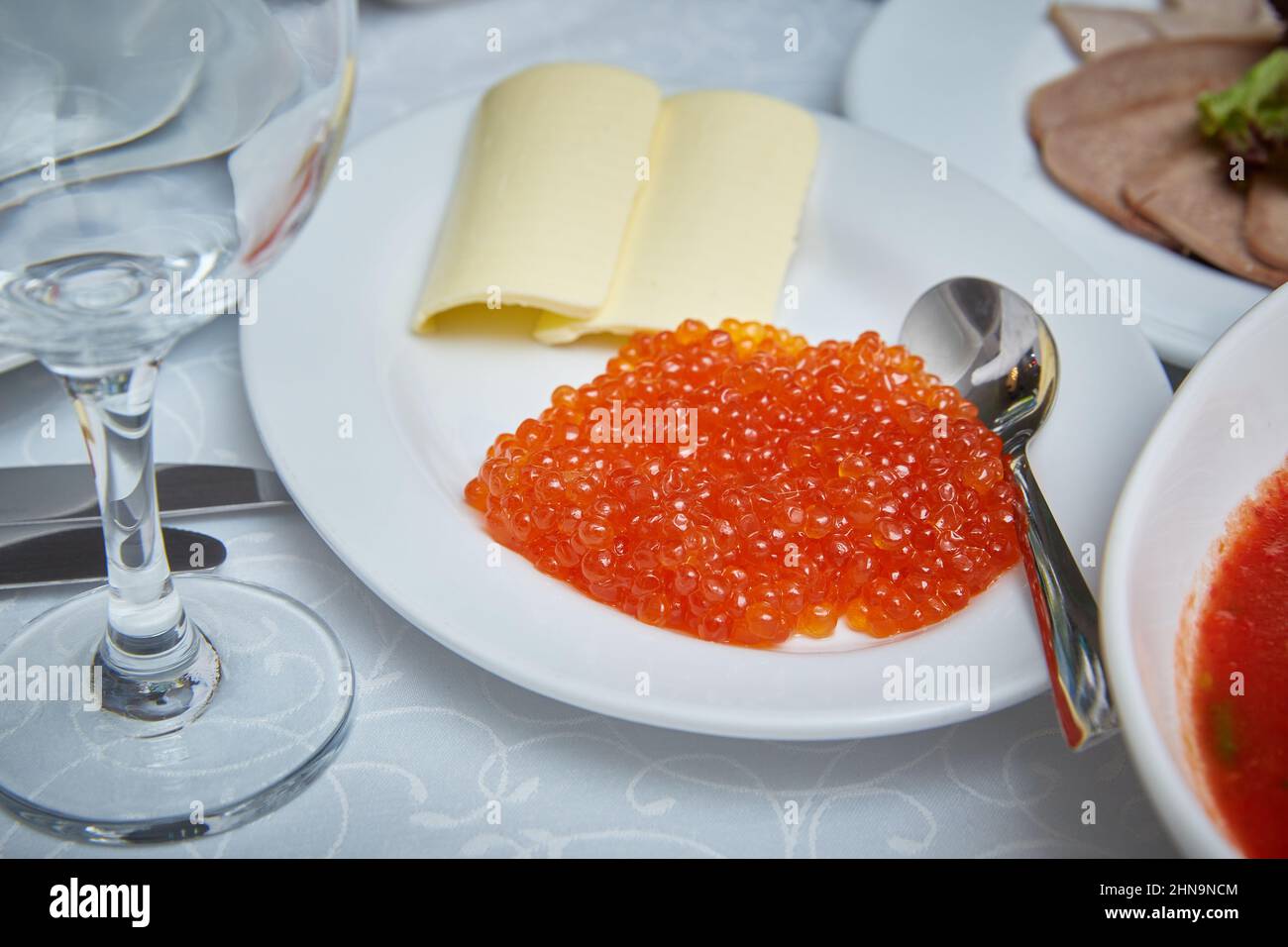 Im Restaurant werden Gerichte serviert. Roter Kaviar auf einem Teller Stockfoto