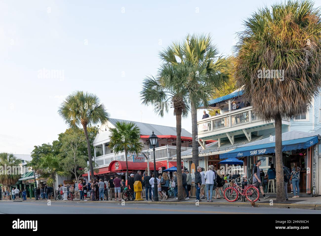 Eine Menschenmenge auf der Straße vor Lucy's Surf Shop und dem Stinkin' Crawfish Canjun Seafood Restaurant in Key West, Florida, USA. Stockfoto