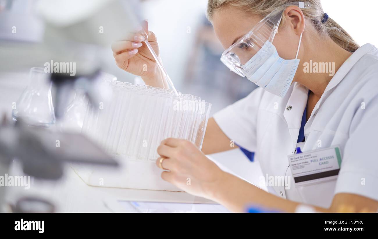 Mit ihrer Forschung die wissenschaftlichen Grenzen überschreiten. Eine junge Wissenschaftlerin, die in ihrem Labor ein Experiment durchführt. Stockfoto