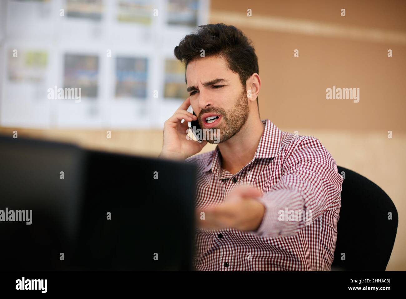 Schau dir das an. Aufnahme eines Geschäftsmannes, der sein Mobiltelefon benutzte, während er an seinem Schreibtisch saß. Stockfoto