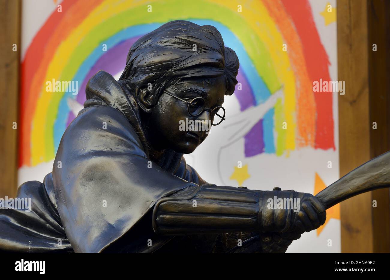 London, England, Großbritannien. Harry Potter-Statue auf dem Leicester Square, vor einem LGBT-Regenbogen Stockfoto