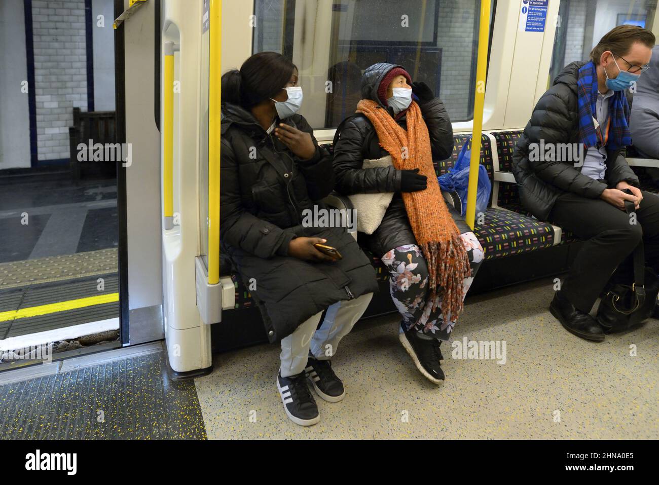 London, England, Großbritannien. Menschen in einem U-Bahn-Zug mit COVID-Masken, 2022 Stockfoto