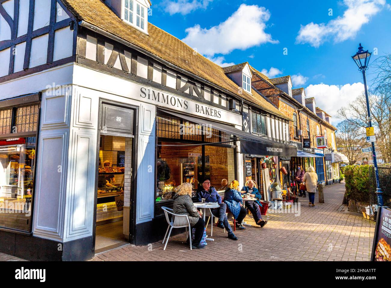 Menschen, die an einem sonnigen Wintertag vor einer Bäckerei sitzen, Kirchhof Walk, Hitchin, Hertfordshire, Großbritannien Stockfoto