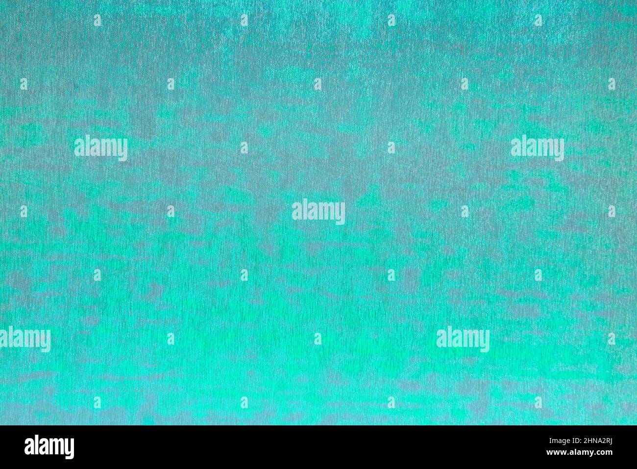 Glatte Oberfläche aus glänzendem metallischem Verpackungsfilm mit Chamäleon-Effekt in intensiver elektrischer Grünfarbe mit grauen Flecken. Abstrakter Hintergrund mit Kopie sp Stockfoto