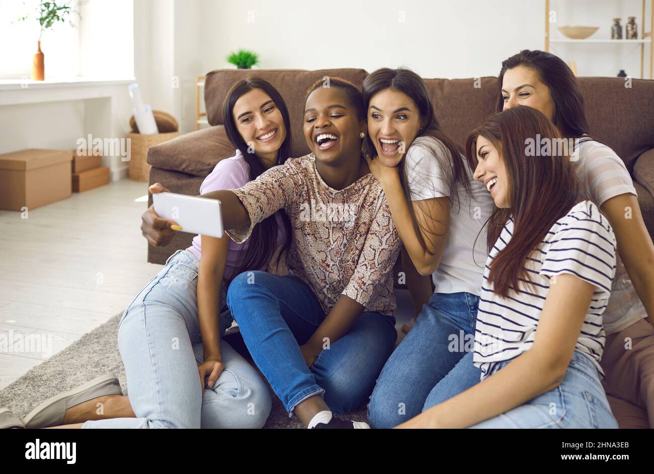 Gesellschaft von multirassischen Freundinnen Spaß haben und Selfies während freundschaftlicher Treffen zu Hause machen. Stockfoto