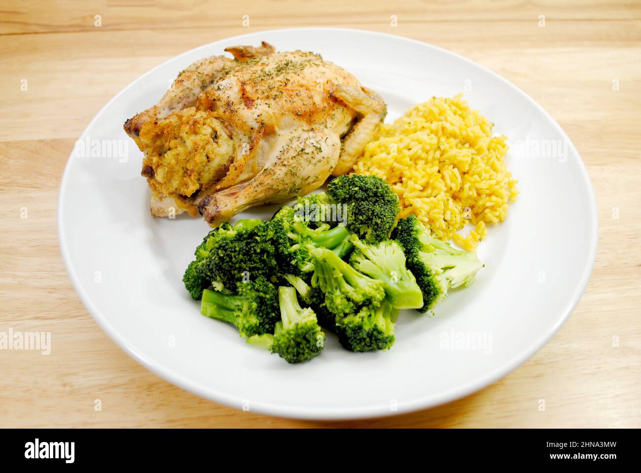 Ein gesundes Abendessen mit Cornish Game Hen, Reice und gedünstetem Broccoli Stockfoto