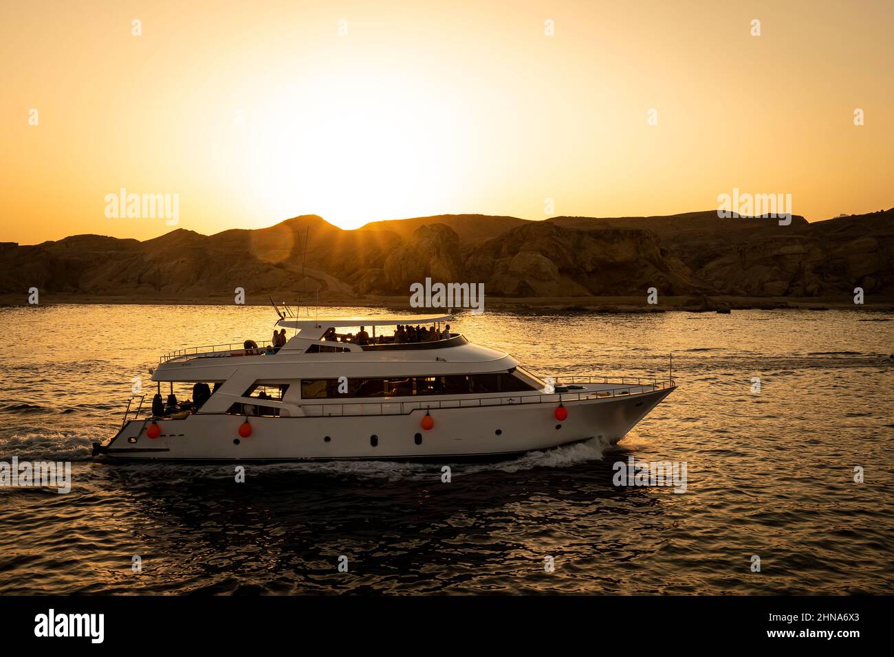 Touristen fahren auf einer zweistöckigen Yacht auf dem Roten Meer vor dem Hintergrund eines hellen Sonnenuntergangs. Sharm el Sheikh Ägypten. 15. Oktober 2021 Stockfoto