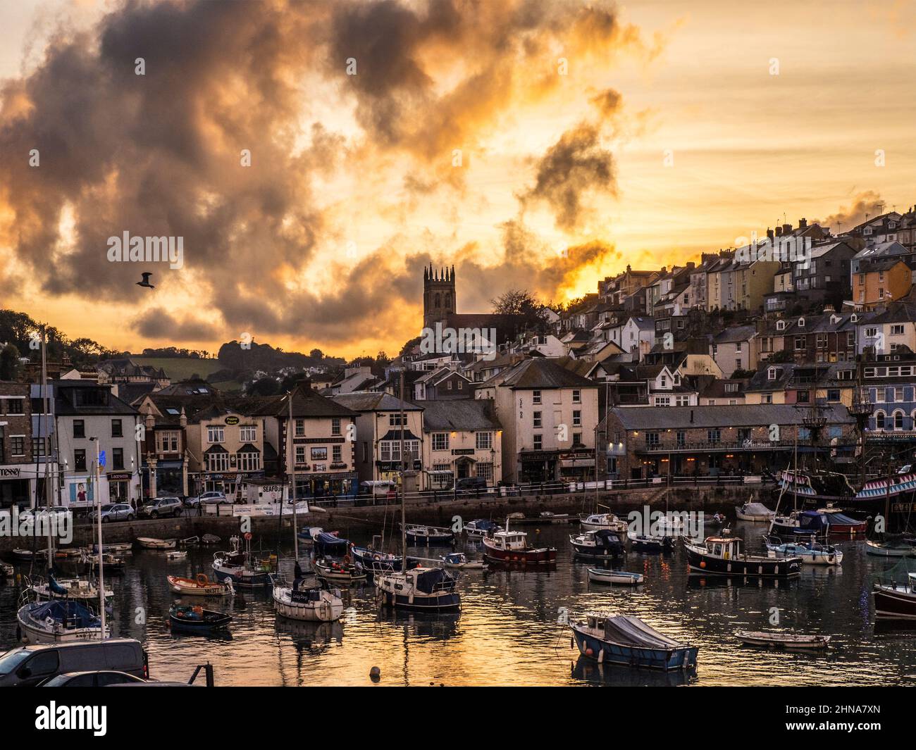 Ein dramatischer stürmischer Sonnenuntergang über der Allerheiligen-Kirche in Brixham, Devon. Stockfoto