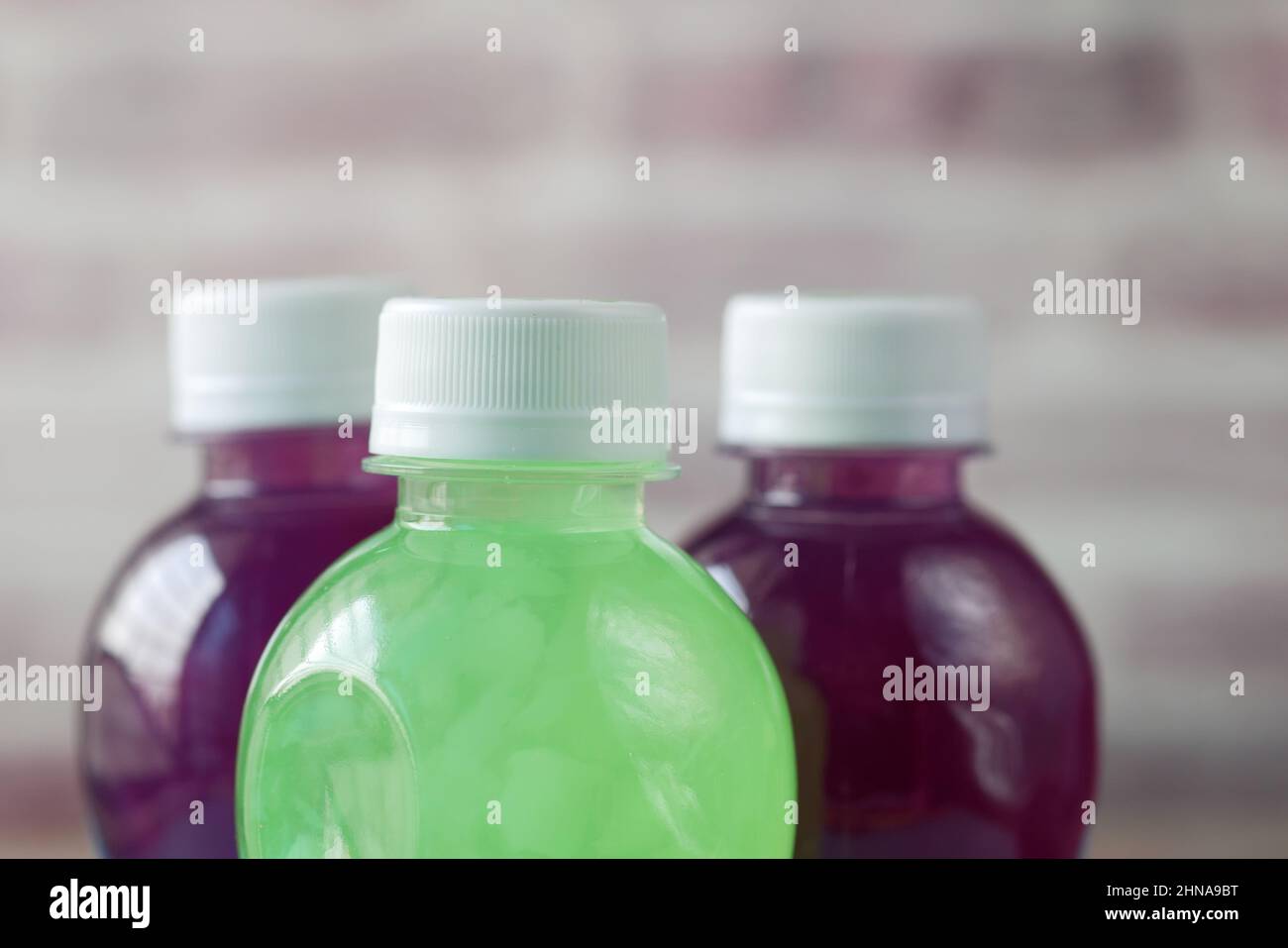 Drei Plastikflaschen mit alkoholfreien Getränken auf dem Tisch Stockfoto