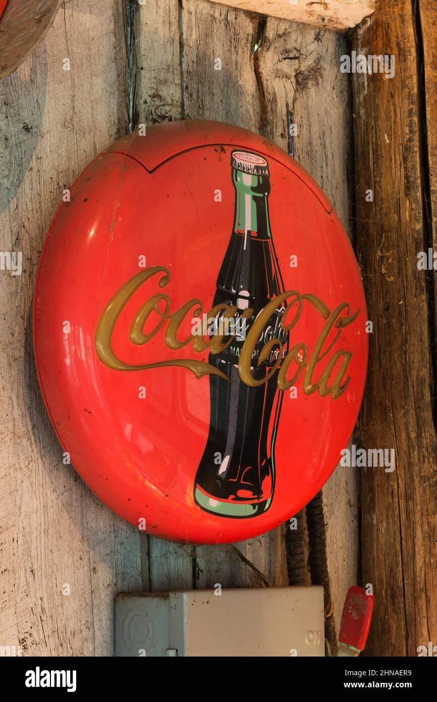 Vintage Coca Cola Neon Werbeschild an der Wand in der alten rustikalen Holzdiele-Hütte. Stockfoto