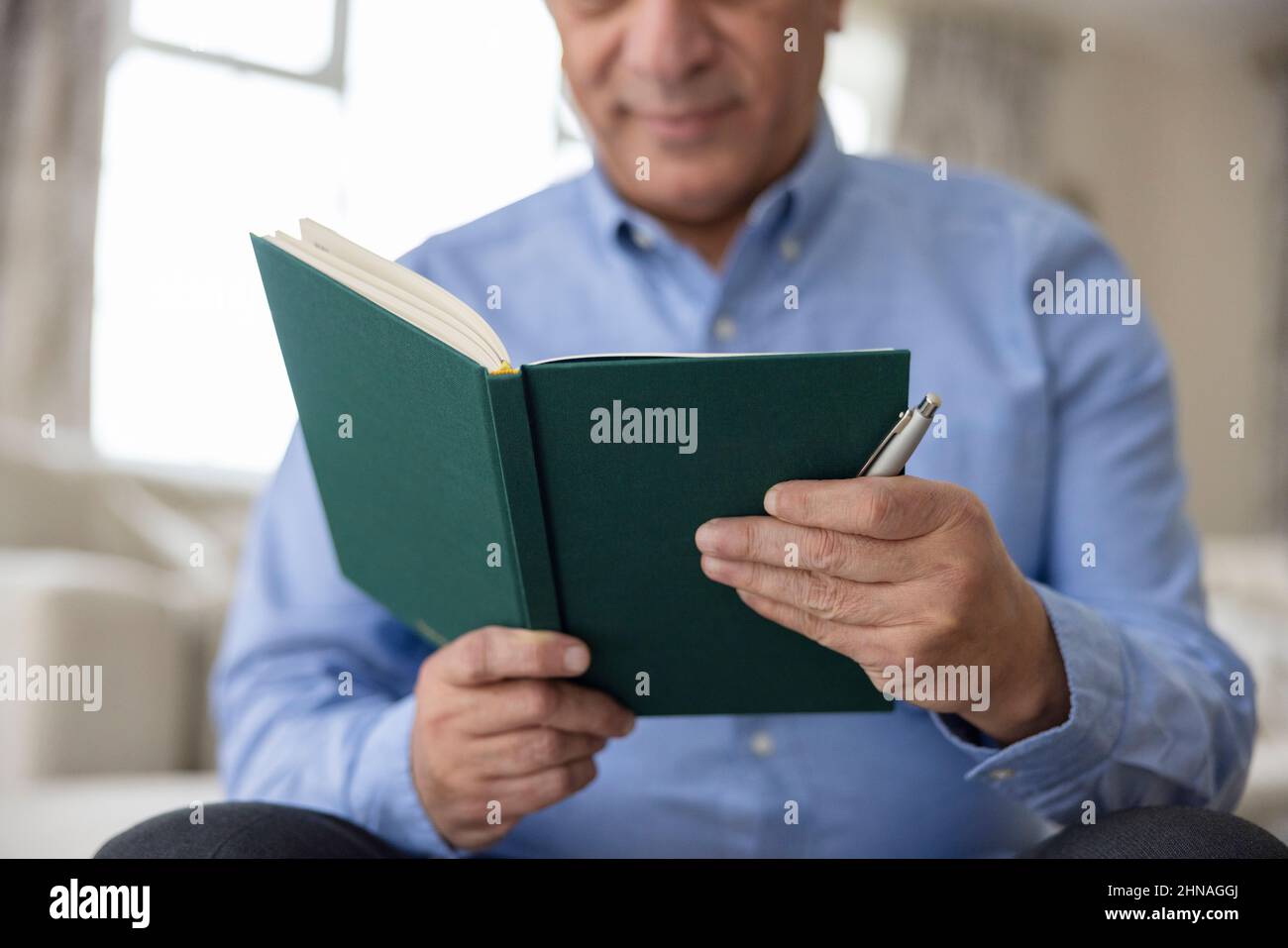 Nahaufnahme Von Man Writing In Diary Oder Journal At Home Stockfoto