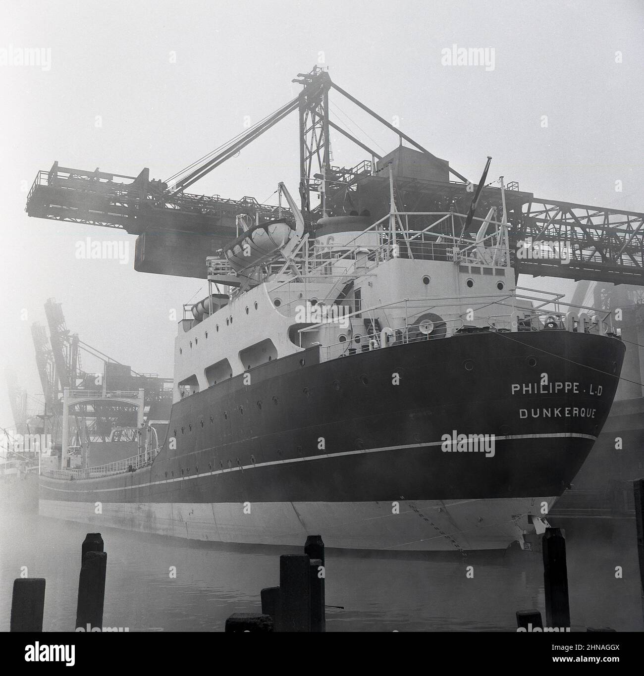 1950s, historisch, das Louis Dreyfus Containerschiff, Philippe. L.D. II) von Dunkerque, der auf dem Industriedock in Port Talbot, Wales, Großbritannien, mit schwerer Stahlladung verladen wurde. Im Auftrag der Steel of Company of Wales wurde dieses Schiff gebaut, das zweite mit dem Namen Philppe LD. Ein Erzträger mit einem All-Aft-Design und einem flachen Tiefgang das Schiff wurde speziell für die industriellen britischen Häfen entwickelt. Die schwimmenden Docks schlossen 1959 für die Schifffahrt. Stockfoto