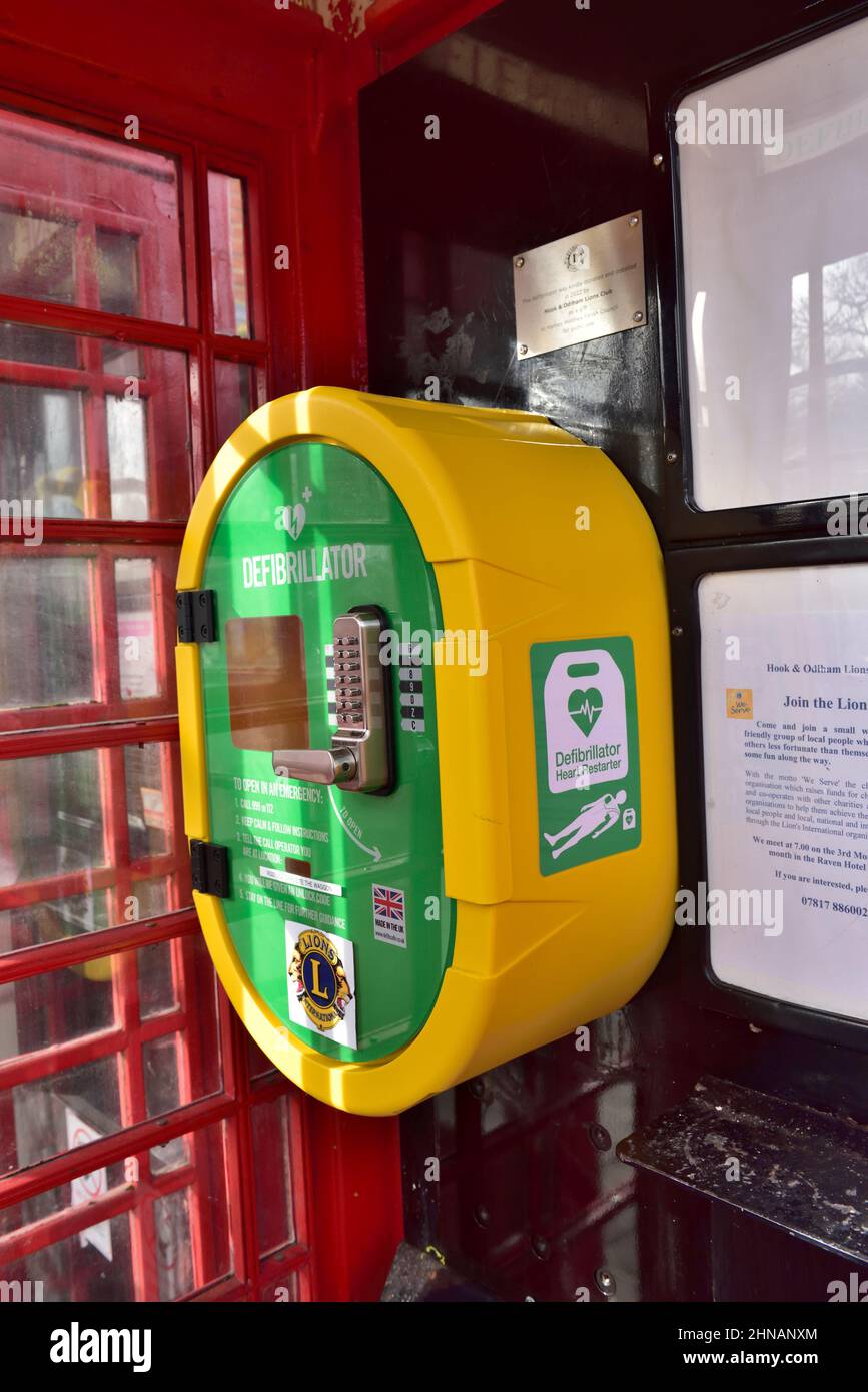 Defibrillator in der umfunktionierten roten traditionellen Telefonbox, Hartley Wintney, Hampshire, Großbritannien Stockfoto