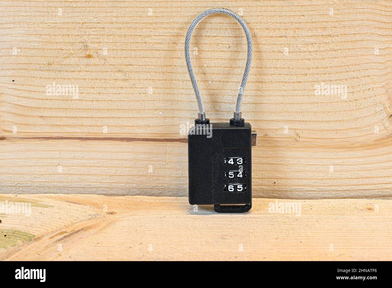 Kleiner Codelock mit Draht, der auf einer Holzbank steht Stockfoto