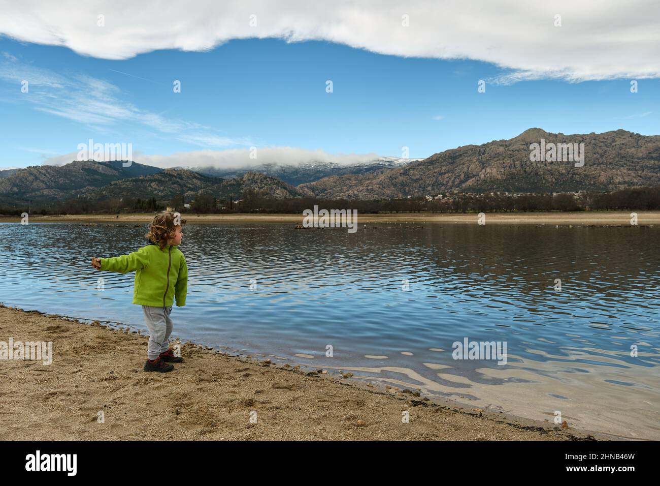 Kind spielt in der Natur, wirft Steine ins Wasser. Stockfoto