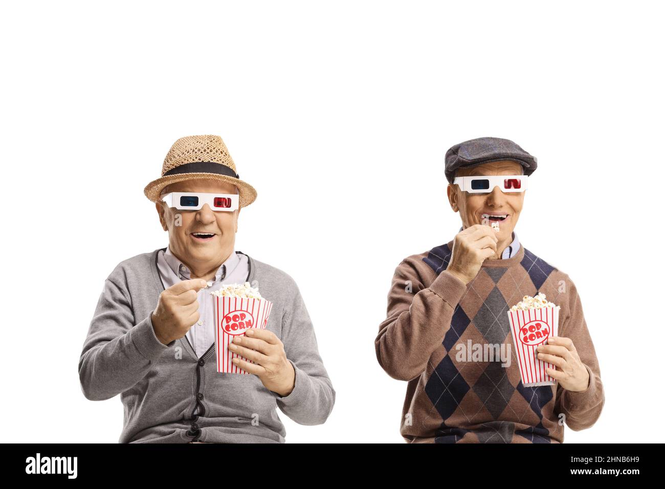 Zwei ältere Männer essen Popcorn und sehen sich einen Film mit 3D Gläsern isoliert auf weißem Hintergrund an Stockfoto