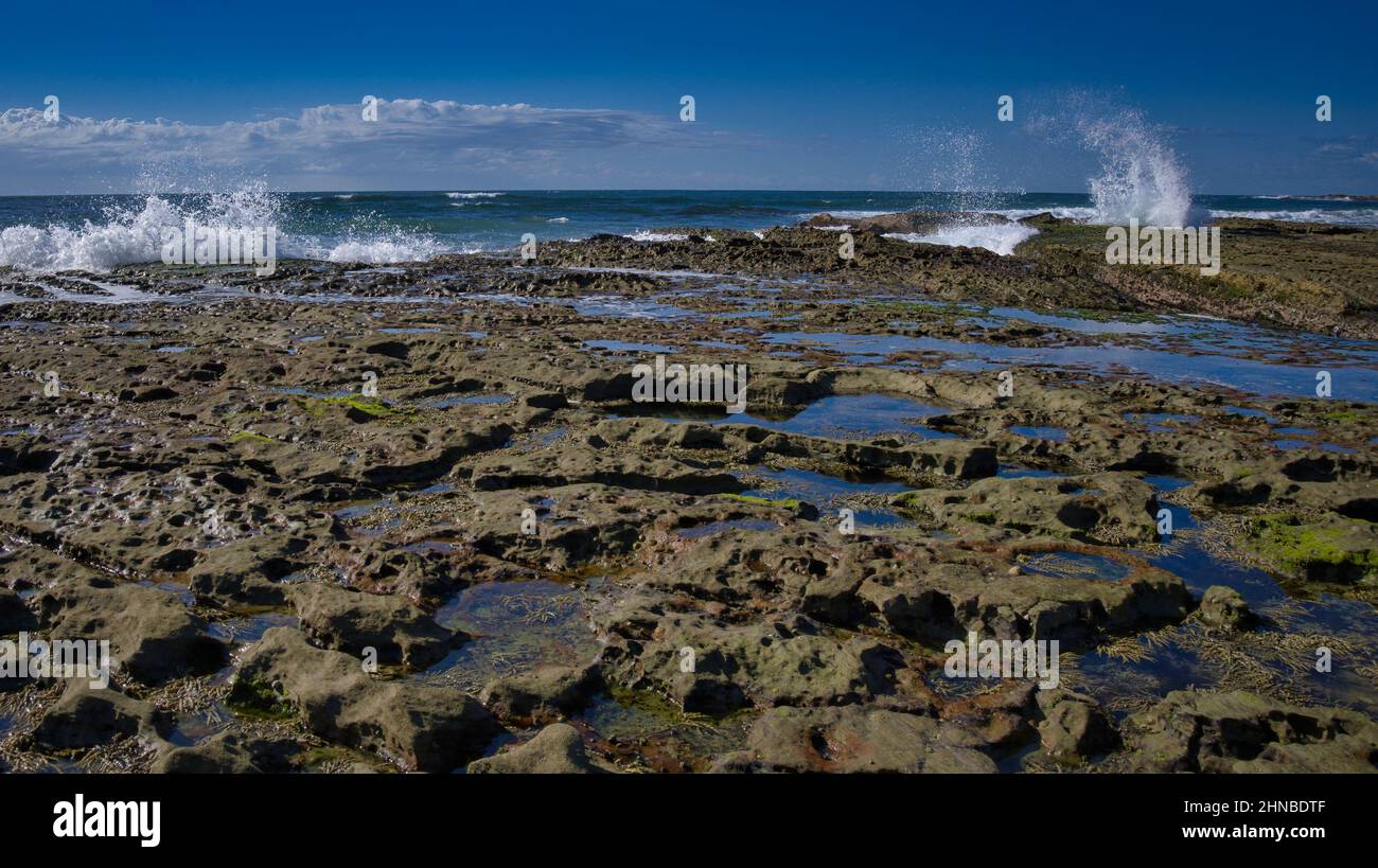Die Wellen schlagen in die Felsen am beliebten Urlaubsziel am Eingang von NSW Australia Stockfoto
