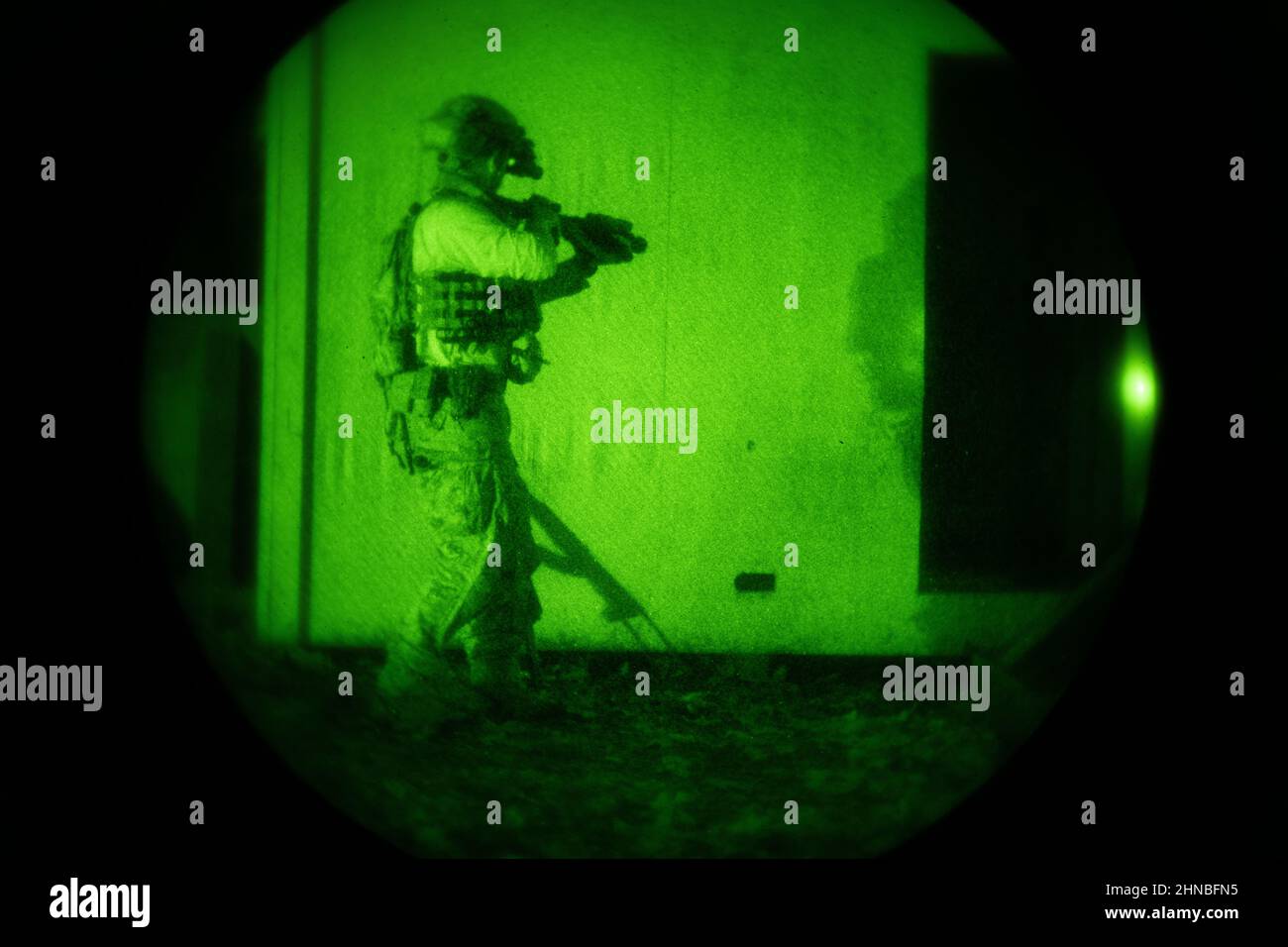 Ein US-Navy-SIEGEL bewegt sich während des Landkriegstrainings am 11. März 2021 in Richtung einer Tür. Der MC-12W vom Special Operations Wing 137th unterstützte die Operatoren der Spezialkriegsführung als „Augen am Himmel“ und sorgte gleichzeitig für Bodeninformationen und Überwachung, die ihnen dabei halfen, während des Trainingsszenarios sicher und effektiv zu navigieren. (USA Foto der Air National Guard von Senior Master Sgt. Andrew M. LaMoreaux) Stockfoto