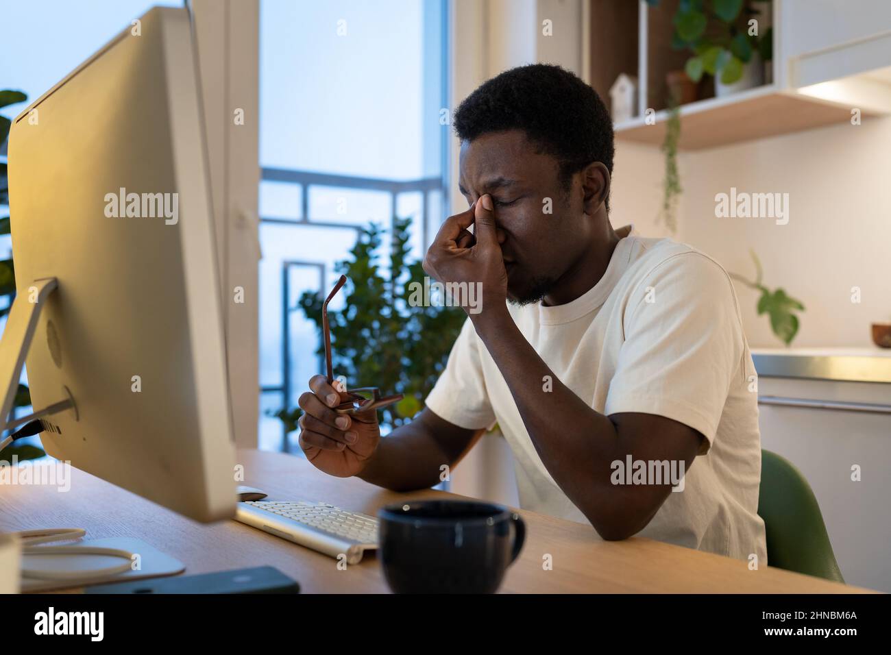 Müde Kerl Remote-Web-Entwickler ausziehen Brille fühlen Augenbelastung nach Überstunden Computer Arbeit zu Hause Stockfoto