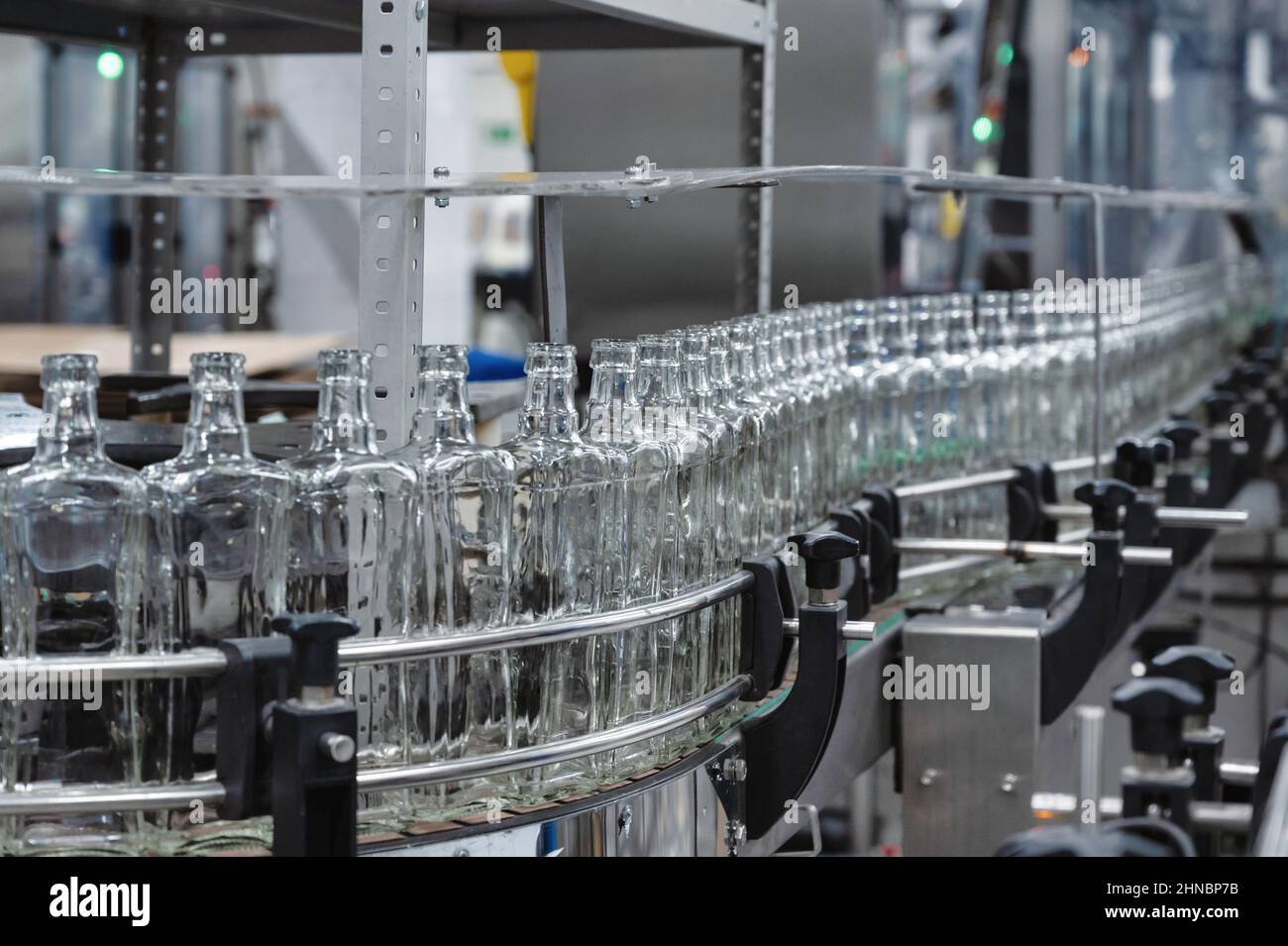 Lange Reihe leerer Glasflaschen für Alkoholgetränke im Werk Stockfoto