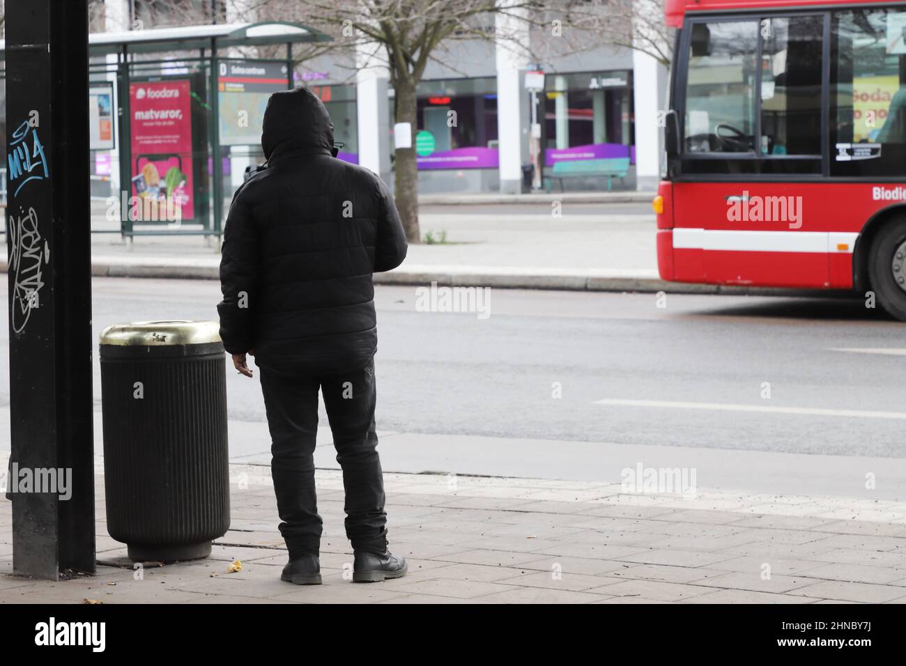 Solna, Schweden - 27. November 2021: Eine Person wartet an der Bushaltestelle Solna Centrum, Stockfoto