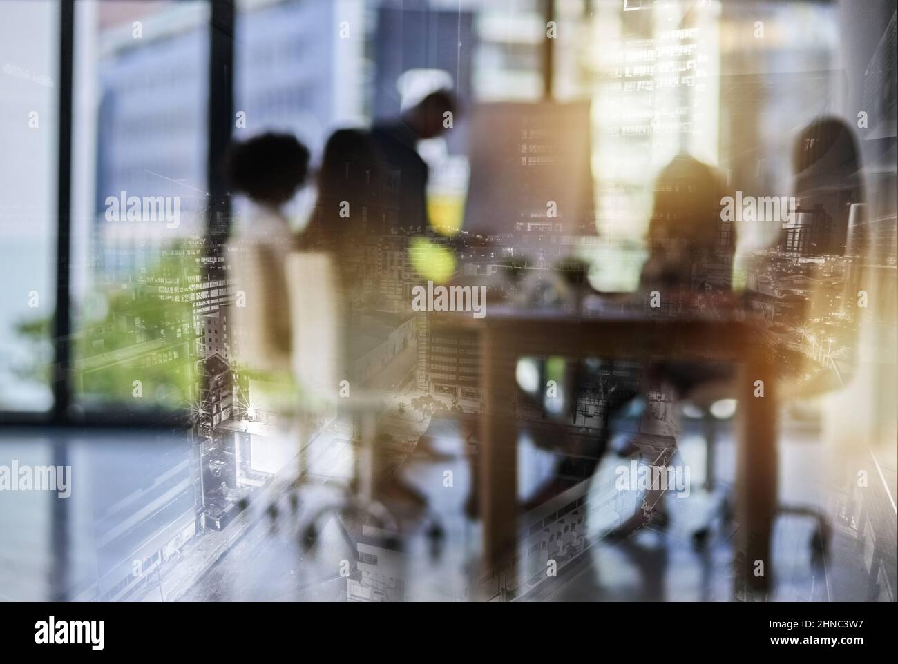 Ideen, die Städte bauen. Aufnahme eines Teams von Geschäftsleuten, die sich in Brainstorming-Arbeit befinden, die doppelt exponiert sind, mit einem Bild einer Stadt. Stockfoto