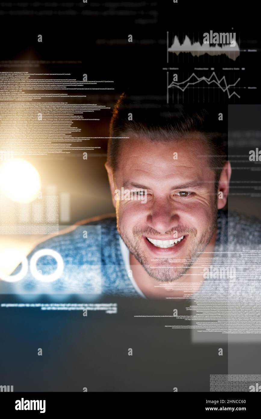 Metadaten sind sein Spielplatz. Aufnahme eines lächelnden Computerprogrammierers, der spät in der Nacht an seinem Computer arbeitet. Stockfoto