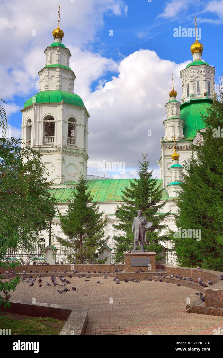 Krasnojarsk, Sibirien, Russland-09.01.2021: Statue des russischen Künstlers 'Surikov Wassili Iwanowitsch' vor dem Hintergrund der ältesten Kirche des XV Stockfoto