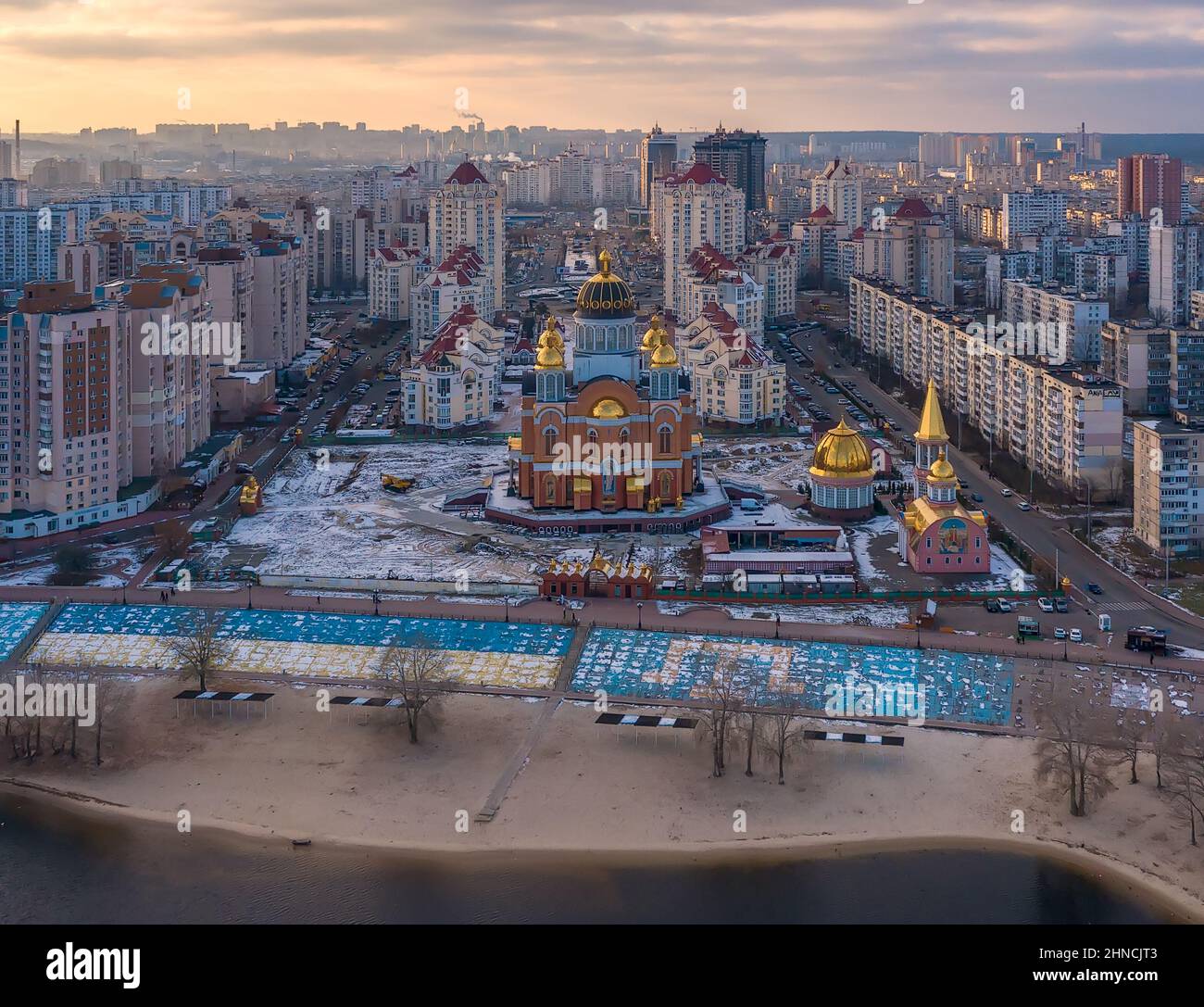 Luftaufnahme der Sviato-Pokrovskyi Kathedrale, Kirche und Straße von oben, Stadtbild des Obolon-Viertels bei Sonnenuntergang, Skyline der Stadt Kiew, Ukraine Stockfoto