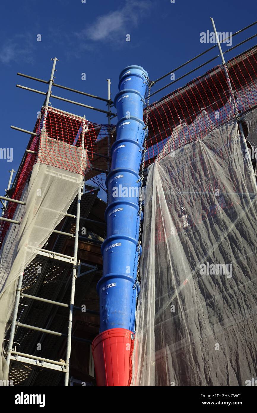 Blaue und rote Schuttrutsche, rotes Schutznetz, Kunststoffflächen, Konstruktionskonzept, Reinigung und Entrüttung (vertikal) Stockfoto